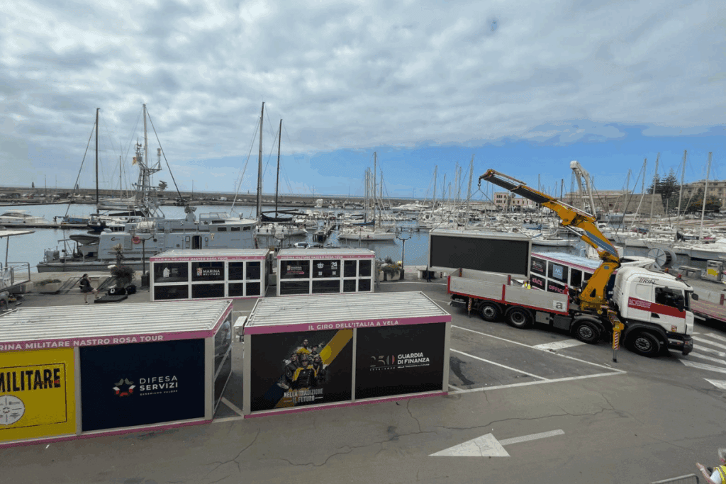 Immagine di un'area portuale con container e attrezzature di supporto.